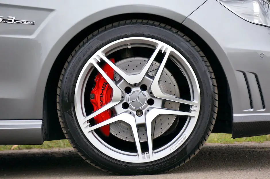 A close-up photograph of a shiny chrome lug nut with tire treads on the background.