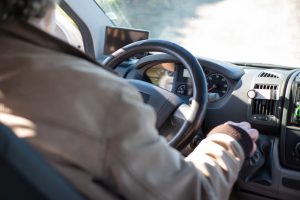 Man driving his car and the steering wheel showing